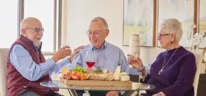 Two men and a woman sharing a drink smiling