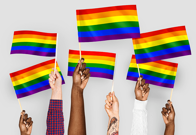 Hands of multiple colors waving pride rainbow flags