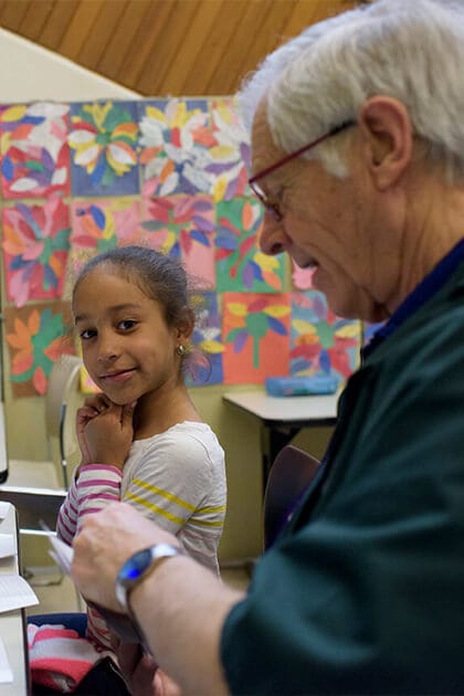 Senior volunteer works with young girl at tutoring session