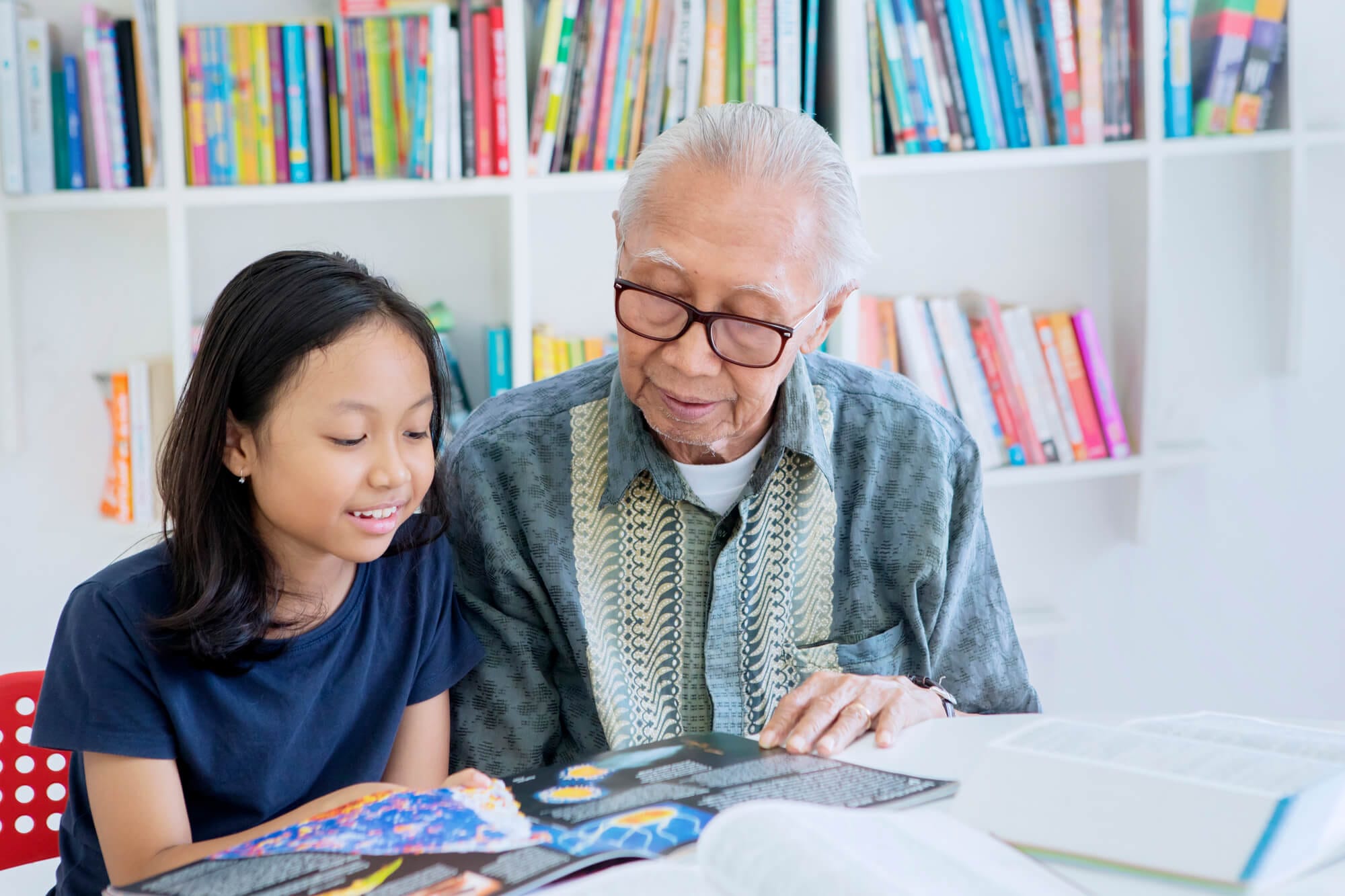 Volunteerism, Reading Tutor. Elderly man reading with child.