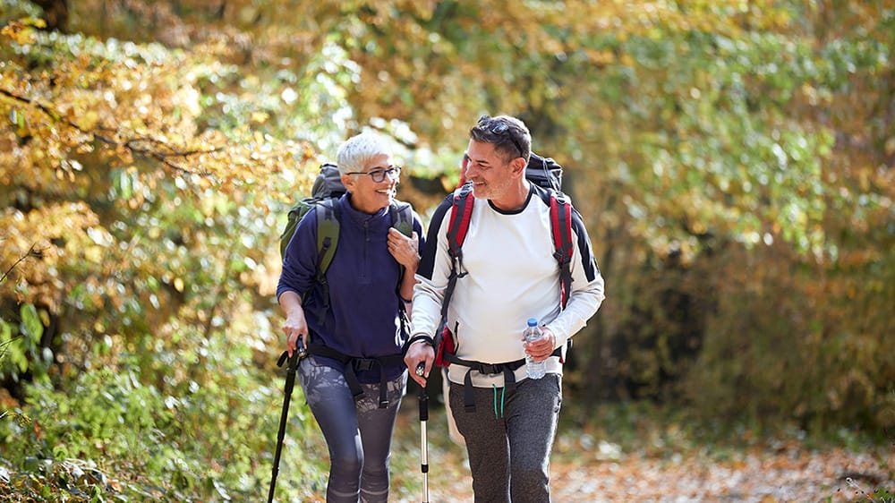 Activities in your own backyard. Older man and woman hiking together.