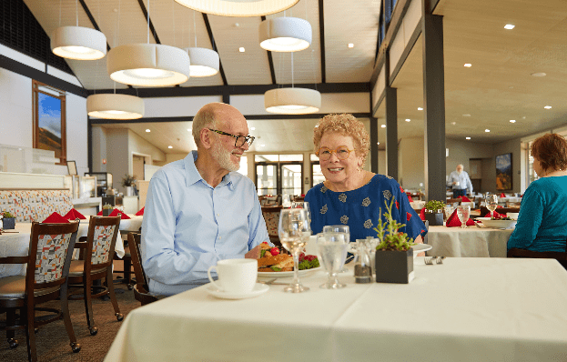 elderly couple sat at dining table in dining room.