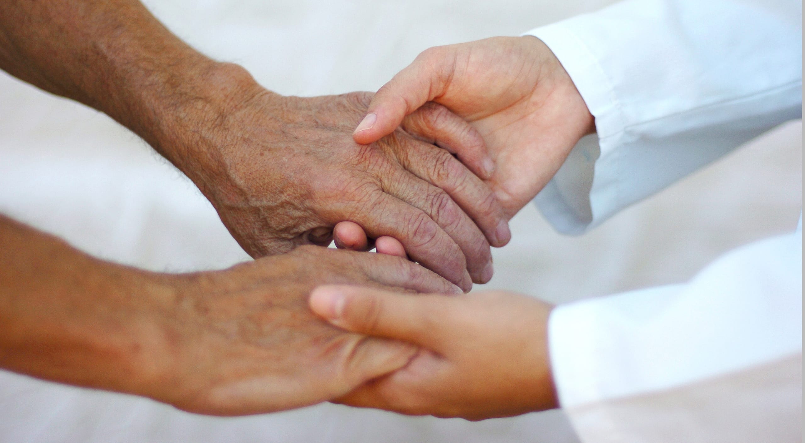 Assisted Living options. Hands of elderly person holding hands with doctor.
