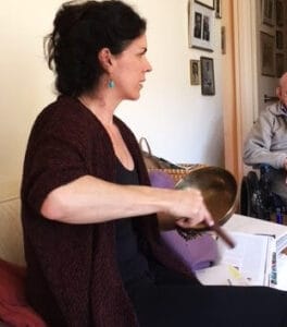 Samantha with a Himalayan singing bowl in a resident's apartment