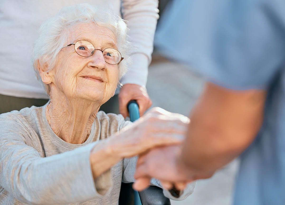 older woman, holding hand, skilled nursing