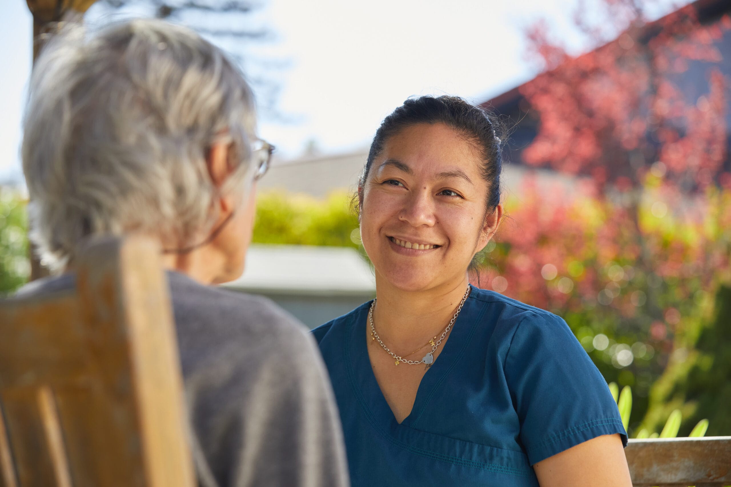 Skilled Nursing, nurse smiling at resident, outdoors in a community garden