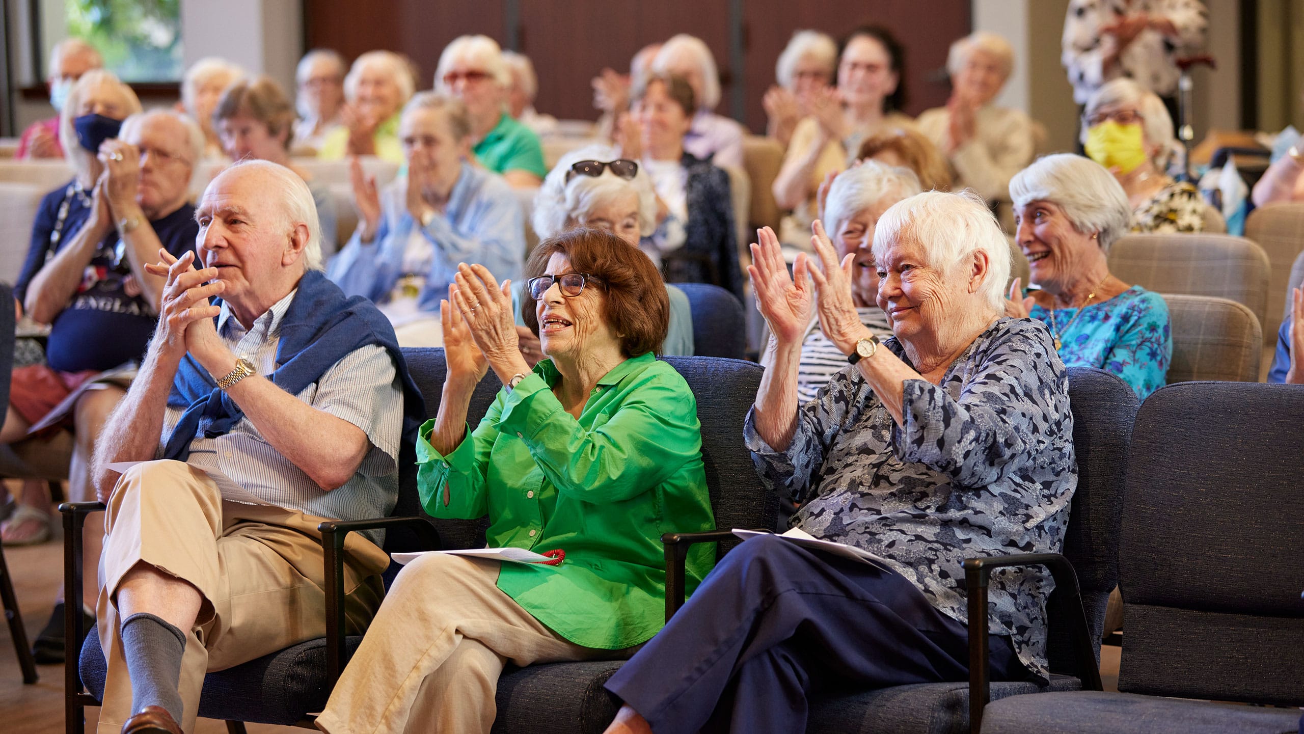 Learn About The Tamalpais Marin Three residents sit applauding a performance