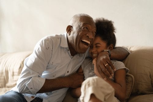 Elderly man laughing with child