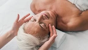 elderly woman receiving a massage in a spa