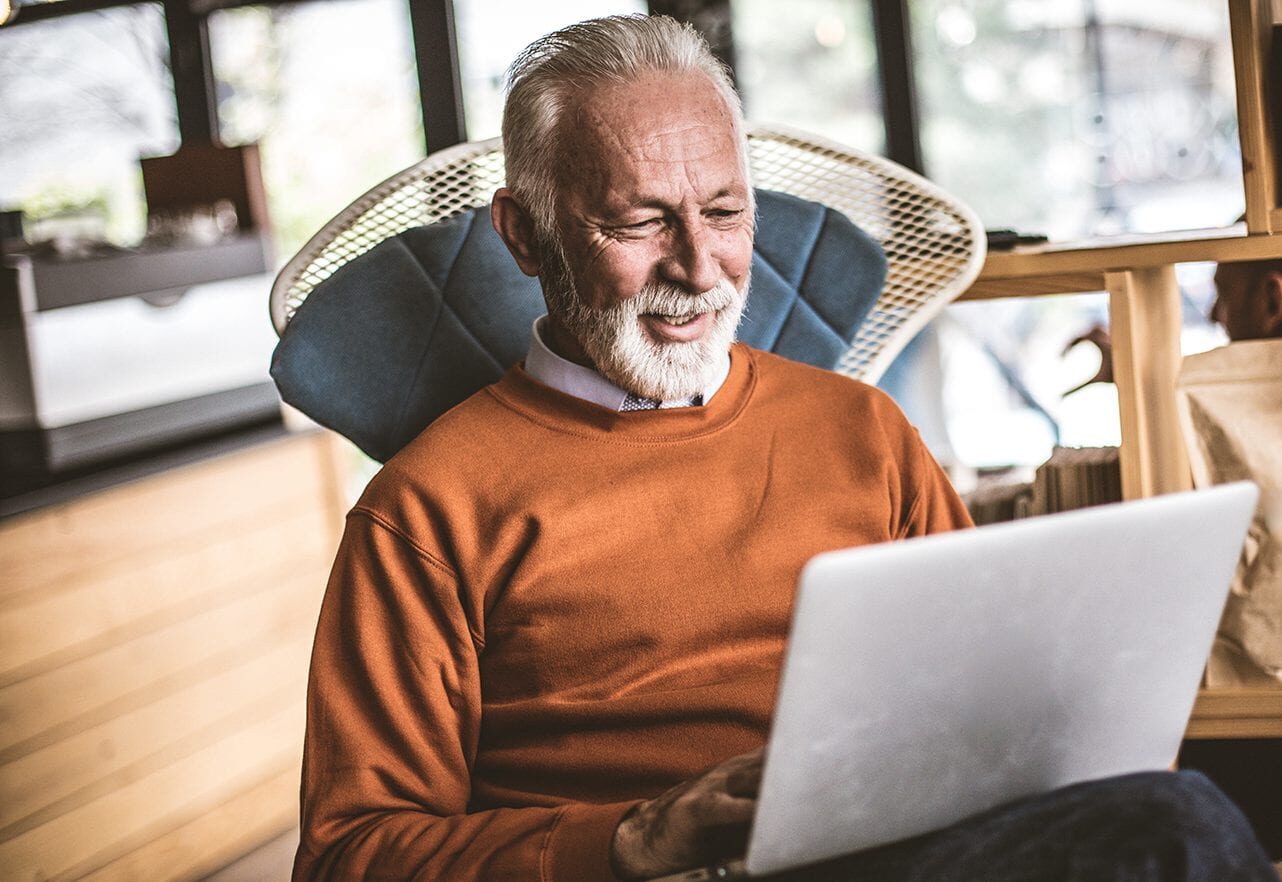 shutterstock_1086660734 elderly man sitting and using laptop