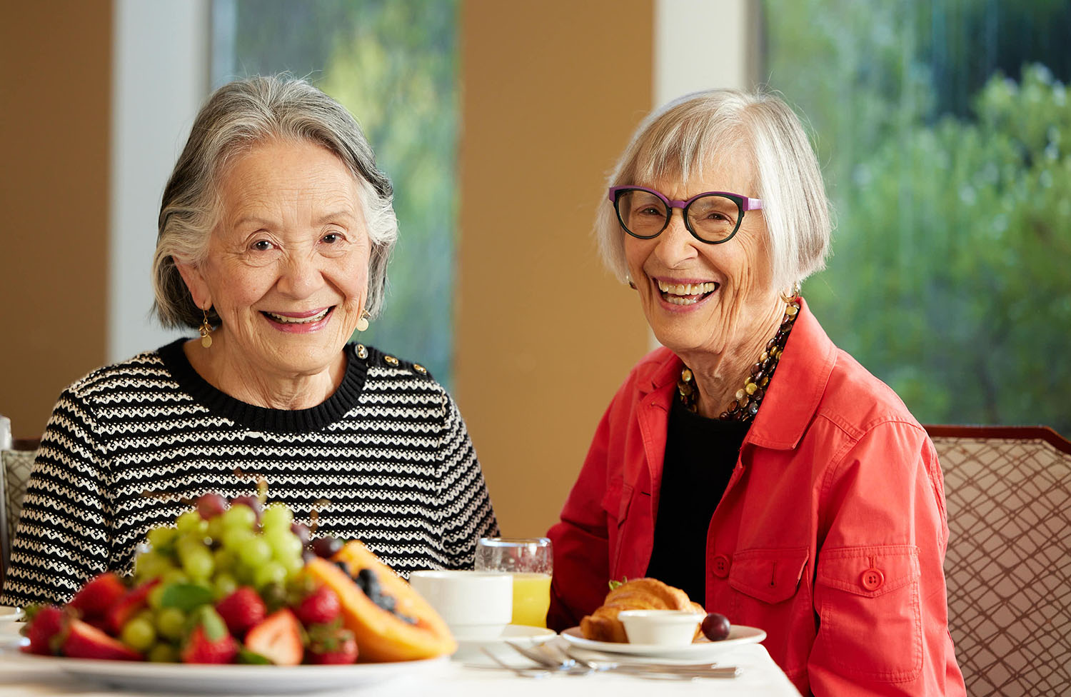two women smiling at the camera. enjoying healthy breakfast foods