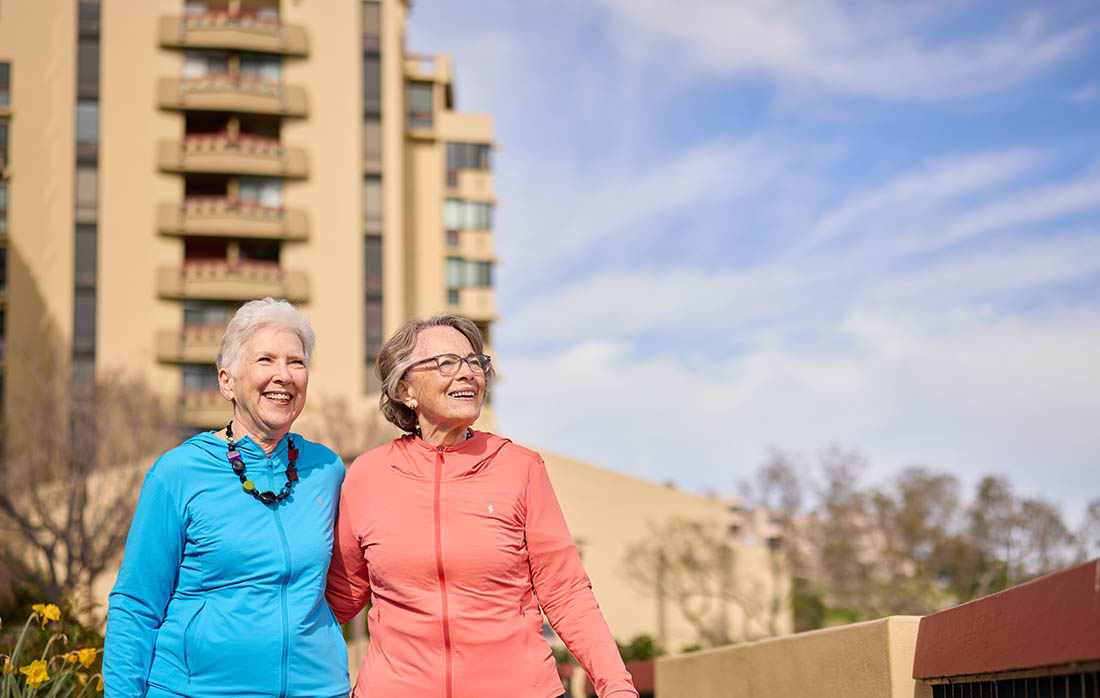 Why Where You Live Matters | TAM Residents | Two female Friends | Residents Walking outdoors with The Tamalpais Marin building on background